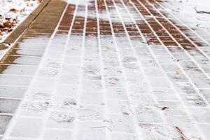 Paving paths in the park, covered with the first snow in winter. photo