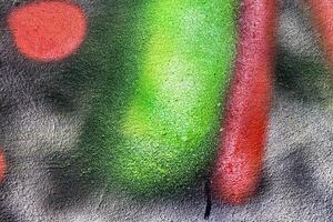 A fragment of colorful graffiti painted on a wall. Abstract urban background. photo