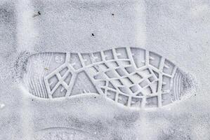 Boot track on thin first snow in winter. photo