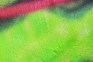 A fragment of colorful graffiti painted on a wall. Abstract urban background. photo