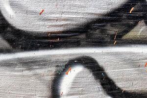 A fragment of colorful graffiti painted on a wall. Abstract urban background. photo