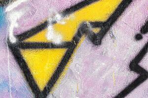 A fragment of colorful graffiti painted on a wall. Abstract urban background. photo