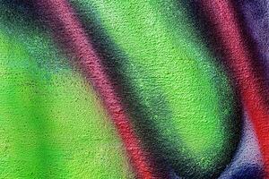 A fragment of colorful graffiti painted on a wall. Abstract urban background. photo