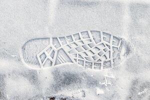 Boot track on thin first snow in winter. photo
