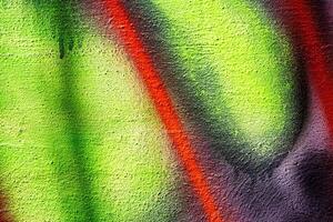 A fragment of colorful graffiti painted on a wall. Abstract urban background. photo