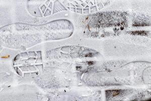Boot track on thin first snow in winter. photo