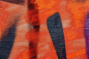 A fragment of colorful graffiti painted on a wall. Abstract urban background. photo