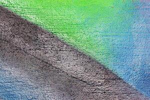 A fragment of colorful graffiti painted on a wall. Abstract urban background. photo