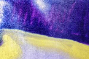 A fragment of colorful graffiti painted on a wall. Abstract urban background. photo