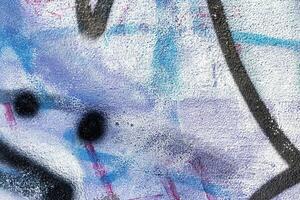 A fragment of colorful graffiti painted on a wall. Abstract urban background. photo