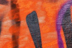 A fragment of colorful graffiti painted on a wall. Abstract urban background. photo