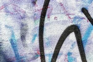 A fragment of colorful graffiti painted on a wall. Abstract urban background. photo