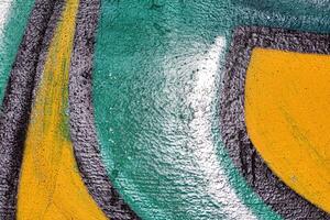 A fragment of colorful graffiti painted on a wall. Abstract urban background. photo