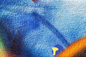 A fragment of colorful graffiti painted on a wall. Abstract urban background. photo