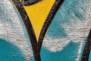 A fragment of colorful graffiti painted on a wall. Abstract urban background. photo