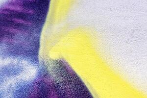 A fragment of colorful graffiti painted on a wall. Abstract urban background. photo