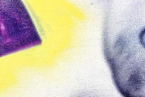 A fragment of colorful graffiti painted on a wall. Abstract urban background. photo