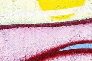 A fragment of colorful graffiti painted on a wall. Abstract urban background. photo