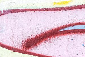 A fragment of colorful graffiti painted on a wall. Abstract urban background. photo
