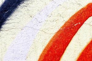 A fragment of colorful graffiti painted on a wall. Abstract urban background. photo