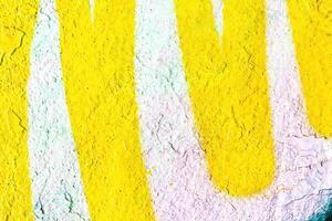 A fragment of colorful graffiti painted on a wall. Abstract urban background. photo