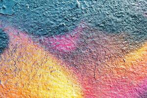 A fragment of colorful graffiti painted on a wall. Abstract urban background. photo