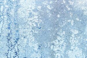 The texture of the glass covered with frost in winter in cold weather. Abstract background. photo