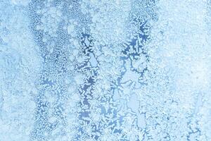 The texture of the glass covered with frost in winter in cold weather. Abstract background. photo
