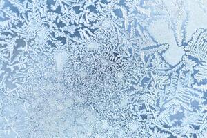 The texture of the glass covered with frost in winter in cold weather. Abstract background. photo