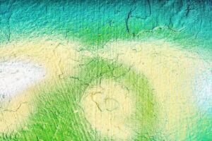 A fragment of colorful graffiti painted on a wall. Abstract urban background. photo