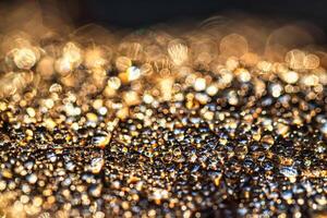Dew drops on an autumn fallen leaf, shimmering in the sun, shot in close-up with bokeh. Abstract macro background. photo