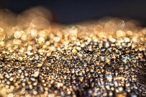 Dew drops on an autumn fallen leaf, shimmering in the sun, shot in close-up with bokeh. Abstract macro background. photo