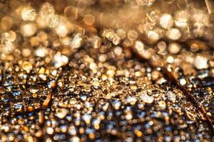 Dew drops on an autumn fallen leaf, shimmering in the sun, shot in close-up with bokeh. Abstract macro background. photo