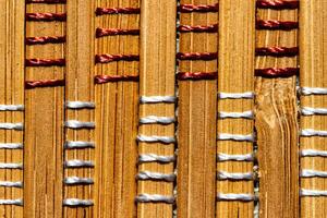 A background of bamboo stems intertwined with threads. photo