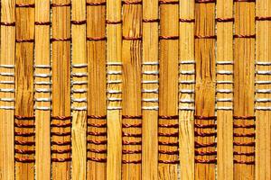 A background of bamboo stems intertwined with threads. photo