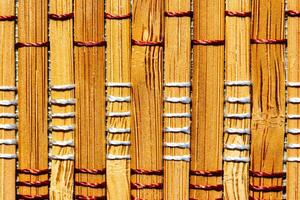 A background of bamboo stems intertwined with threads. photo