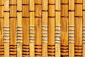 A background of bamboo stems intertwined with threads. photo