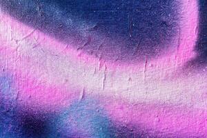 A fragment of colorful graffiti painted on a wall. Abstract urban background. photo