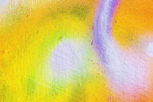 A fragment of colorful graffiti painted on a wall. Abstract urban background. photo