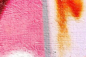 A fragment of colorful graffiti painted on a wall. Abstract urban background. photo