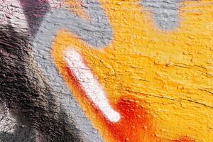 A fragment of colorful graffiti painted on a wall. Abstract urban background. photo