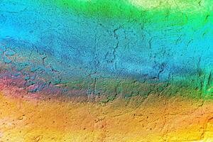 A fragment of colorful graffiti painted on a wall. Abstract urban background. photo