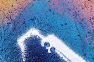 A fragment of colorful graffiti painted on a wall. Abstract urban background. photo