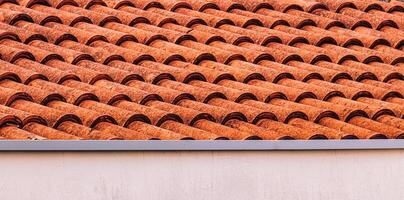 Texture of red clay roof tiles. Abstract backdrop for design. photo