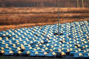 Volkswagen Group Rus, Russia, Kaluga - MAY 25, 2020 Rows of a new cars parked in a distribution center on a sunny morning in the autumn. photo