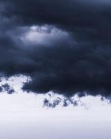 Dark monochrome heavy storm clouds before a thunderstorm or hurricane. Dramatic clouds in overcast weather. photo