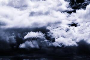 Dark monochrome heavy storm clouds before a thunderstorm or hurricane. Dramatic clouds in overcast weather. photo