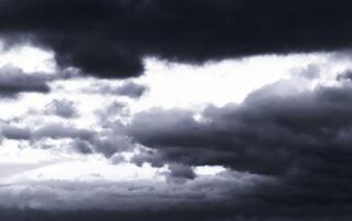 Dark monochrome heavy storm clouds before a thunderstorm or hurricane. Dramatic clouds in overcast weather. photo