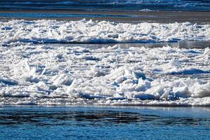Melting ice floating on the river on a spring day. Cracked ice texture. photo