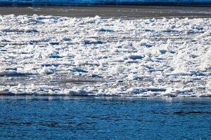 Melting ice floating on the river on a spring day. Cracked ice texture. photo